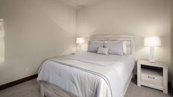 A bedroom with a bed, two bedside tables, and a nightstand.