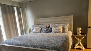 Un dormitorio con cama, mesita de noche y una puerta.