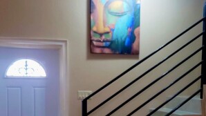 Eine Treppe mit Handlauf und einer Tür mit dekorativem Glasfenster.