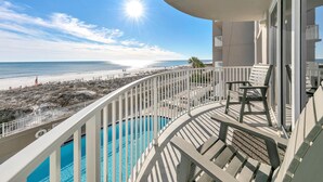 Ein Balkon mit Pool, mit Blick auf Strand und Meer.