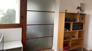 Une pièce avec une armoire, une bibliothèque et une fenêtre.