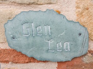 Una placa de piedra con la inscripción "Glenn Lea" colocada en una pared de ladrillo.