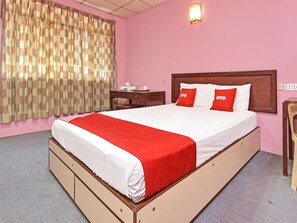 A hotel room with a large bed, a wooden nightstand, a desk, and a chair. - Hotel O Villa De Rose (Johor Bahru)