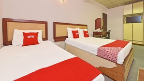 Two beds with wooden headboards, white and red bedding, and a red and white patterned blanket. - Hotel O Villa De Rose (Johor Bahru)