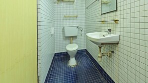 A small bathroom with a toilet, sink, and mirror. - Hotel O Villa De Rose (Johor Bahru)