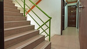 A staircase with brown steps and green handrails leading to a door marked with the number 219. - Hotel O Villa De Rose (Johor Bahru)