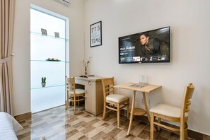 Leilighet – deluxe | Oppholdsområde | En 40-tommers smart-TV med Parabol-TV samt TV og Netflix