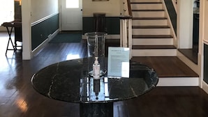 A spacious room with a staircase, a dining table with a glass centerpiece, and a sign on the wall. - The Lodge at the Ranch - secluded but close to Galena and golf. (Elizabeth)