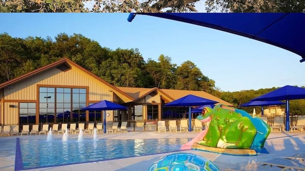 A swimming pool with lounge chairs and umbrellas, surrounded by a building with large windows. - The Lodge at the Ranch - secluded but close to Galena and golf. (Elizabeth)