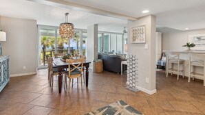 A spacious kitchen with a dining area, a bar, and a view of the outdoors.