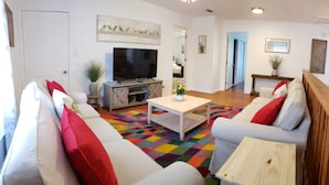A living room with a sofa set, a coffee table, a TV, and a staircase. - Sleeps 22 - Just min to Clearwater Beach & Indian Rocks Beach (Largo)