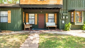 A two-story wooden house with a porch, a red door, and a welcome sign. - Sleeps 22 - Just min to Clearwater Beach & Indian Rocks Beach (Largo)