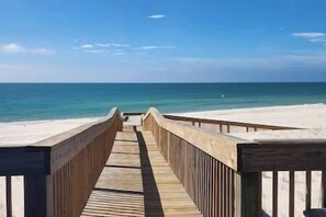 Una passerella in legno che conduce a una spiaggia con vista libera sull'oceano.
