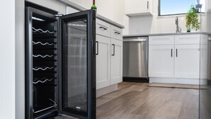 Eine moderne Küche mit Einbaukühlschrank, Edelstahlgeräten und weißen Schränken.