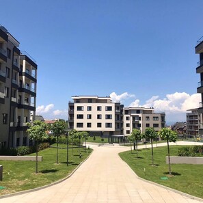 Un immeuble d’appartements moderne doté d’une cour intérieure, de nombreux balcons et offrant une vue sur un ciel dégagé.