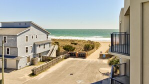 Una proprietà fronte spiaggia con un'area parcheggio, una recinzione in legno e vista sull'oceano.