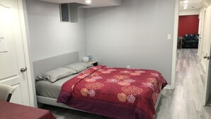 Ein Schlafzimmer mit einem Bett, einem Nachttisch, einem Tisch und einer roten Tür.