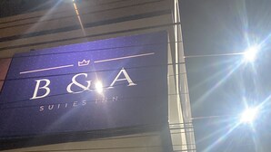 Ein Gebäude mit einem Schild für 'B&A Suites Inn' und einem weiteren Schild für 'B&A'.