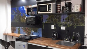 A compact kitchen with a microwave, coffee maker, and a small refrigerator.