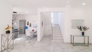 Ein modernes Interieur mit Küche, Essbereich und Treppe.