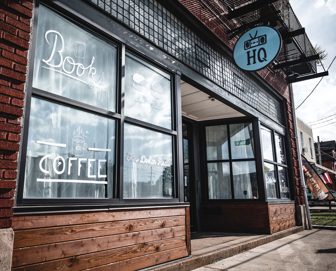 A building with a sign reading "Books Coffee HQ" and a logo for "Two Dollar Radio Headquarters".