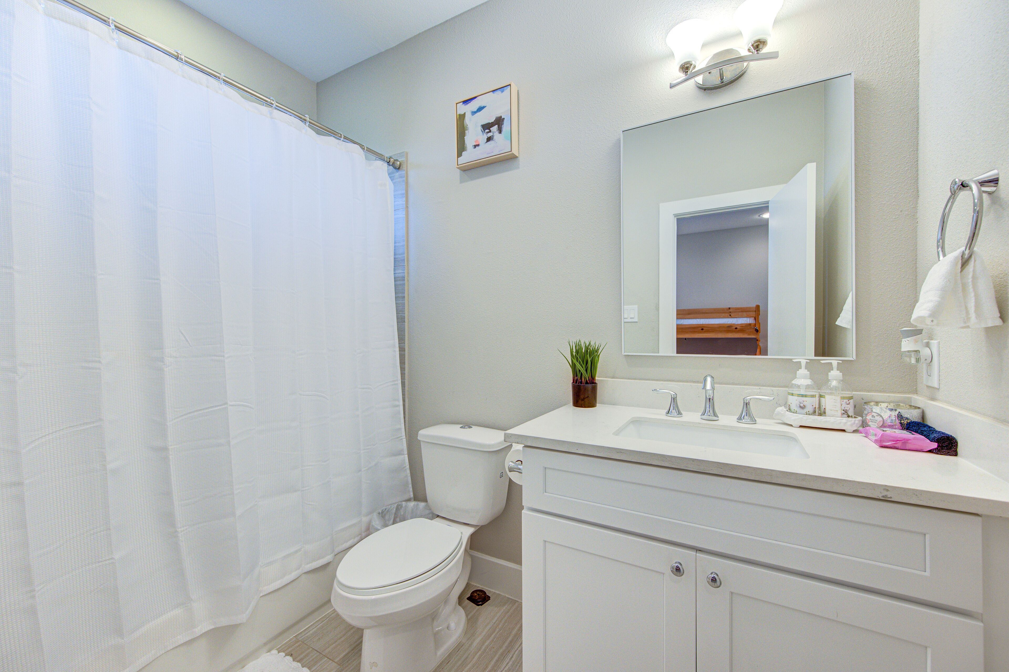 A bathroom with a toilet, sink, and shower curtain.