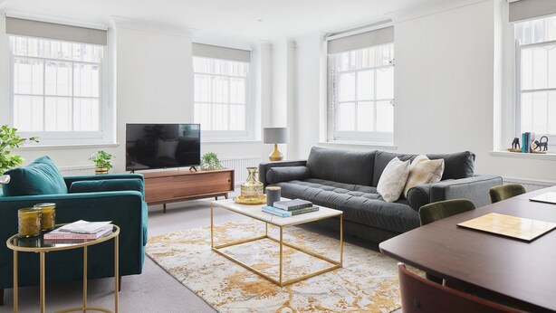 Un salon moderne avec un canapé, une table basse et un téléviseur.