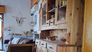 Une cuisine en bois avec des placards intégrés, un coin repas avec un canapé et une décoration murale.