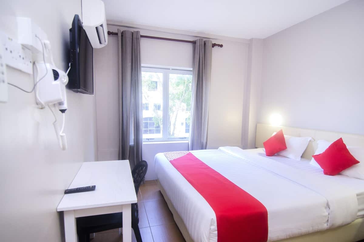 Une chambre d’hôtel avec un lit, un bureau et une fenêtre.