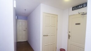 A hallway with white doors, a red basket, and a sign reading "KELUAR". - Hotel O iBC36 Business Stay (Kuching)