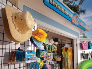 Una tienda con una gran variedad de sombreros y ropa exhibidos en estantes y perchas.