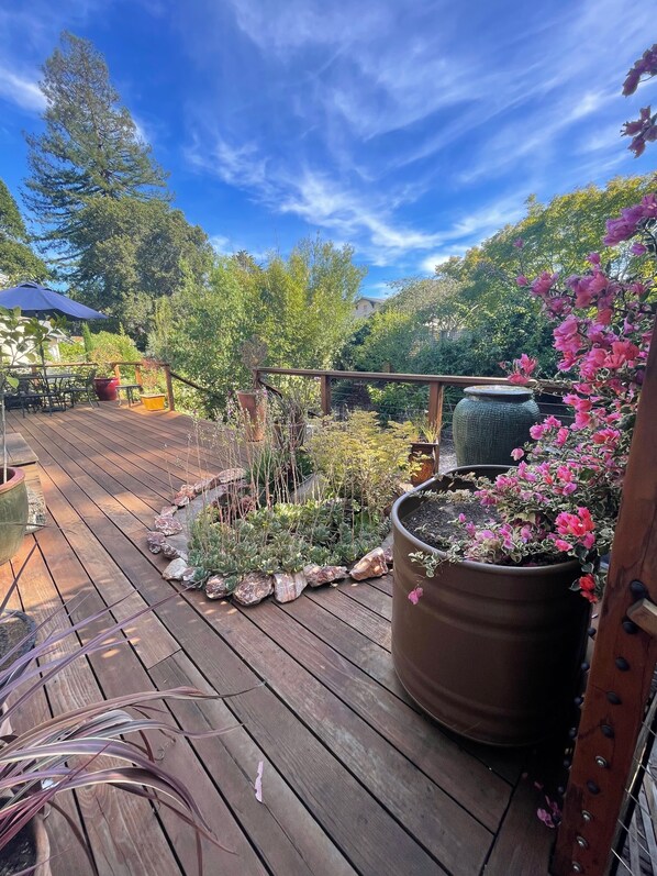 Enjoy a serene outdoor space with a deck surrounded by lush plants and flowers.
