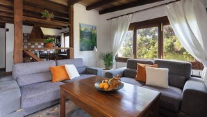 A cozy living room with a sofa set, a wooden coffee table with fruit, and a painting on the wall. - Home2Book Atlantic View Rustic Villa (Los Realejos)