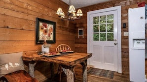 A rustic wooden interior with a wooden dining table, a white door, and a white refrigerator. - PEACOCK RIDGE Great location, minutes from Blowing Rock and Appalachian Ski Mtn! (Blowing Rock)