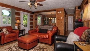 A cozy living room with leather sofas, a ceiling fan, and a view of the adjacent kitchen. - PEACOCK RIDGE Great location, minutes from Blowing Rock and Appalachian Ski Mtn! (Blowing Rock)