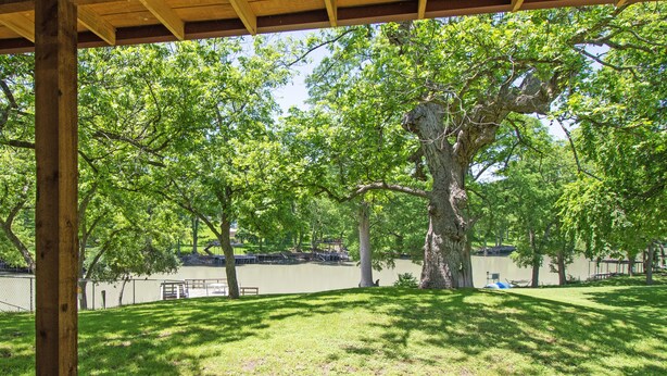 Un espace extérieur abrité offrant une vue sur un lac et des arbres.