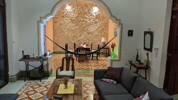 Una sala de estar con un sofá, una mesa de centro y un comedor con sillas y una mesa.