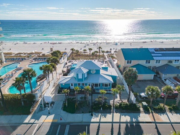 A beachfront hotel with multiple swimming pools, a beach view, and a parking area.
