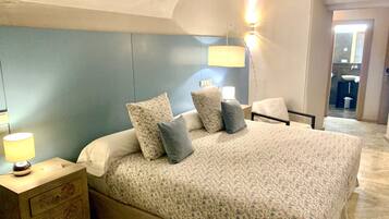 Un dormitorio con cama, mesitas de noche y una lámpara.