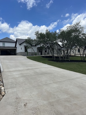 A modern house with a garage, a driveway, and a well-maintained lawn.