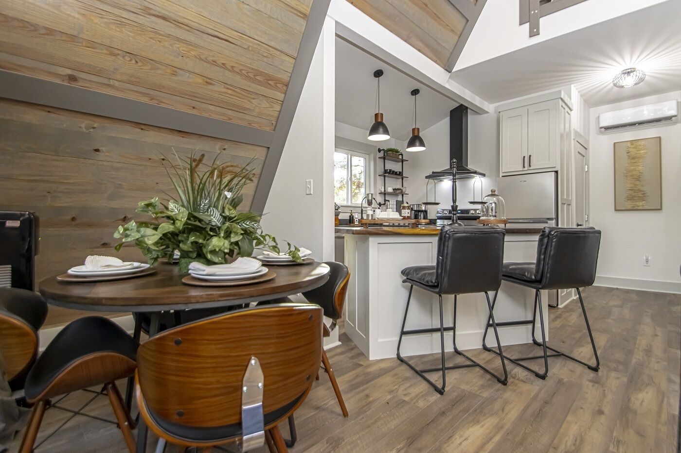 A modern kitchen with white cabinets, a central island, and pendant lighting.