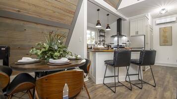 A modern kitchen with white cabinets, a central island, and pendant lighting.