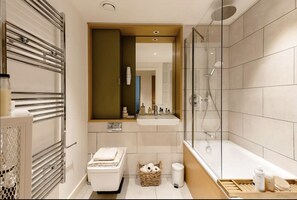 Combined shower/bathtub, towels, soap, toilet paper - Stylish One Bedroom Flat in East London (London)