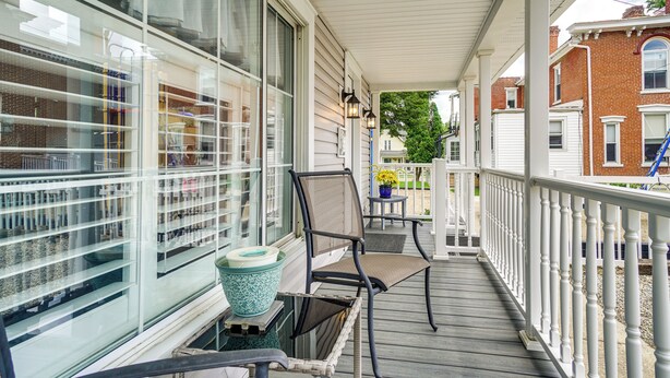A covered porch with two chairs, a potted plant, and a large window. - Quaint Mt Vernon Cottage Near Historic Dtwn! (Mt Vernon)