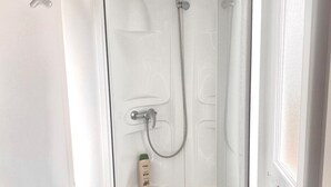 A glass-enclosed shower with a handheld showerhead and a handheld faucet. - Cozy tiny house in nature, 5 mins from Beach | With sea view & high speed WiFi (Tarifa)