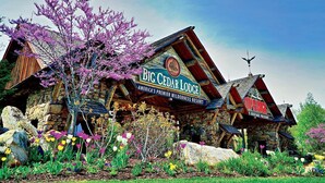 Big Cedar Lodge, a rustic lodge with a prominent sign, surrounded by colorful flowers and a clear blue sky. - FALLS - Shop Till You Drop, Then Relax in a Comfortable Studio Suite (Branson)