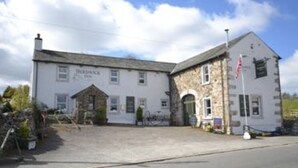 A two-story building with a stone facade and a sign that reads "Herford Inn." - Herdwick Inn (Penrith)