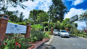 A hotel entrance with a signboard, a paved driveway, and surrounding greenery. - Hotel Villa Zurqui (San Jeronimo)