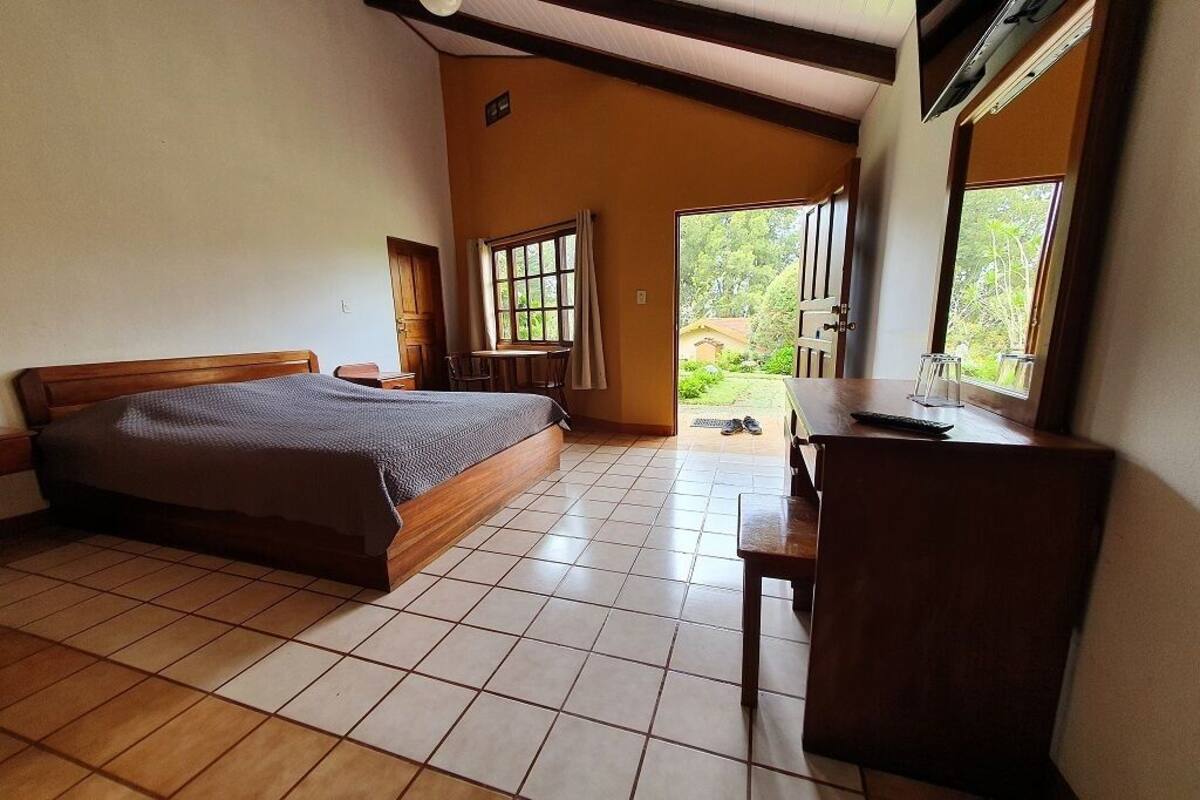 Un dormitorio con una cama, un escritorio y una ventana.