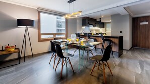 Un comedor moderno con una mesa de vidrio, sillas negras y una lámpara de pie.